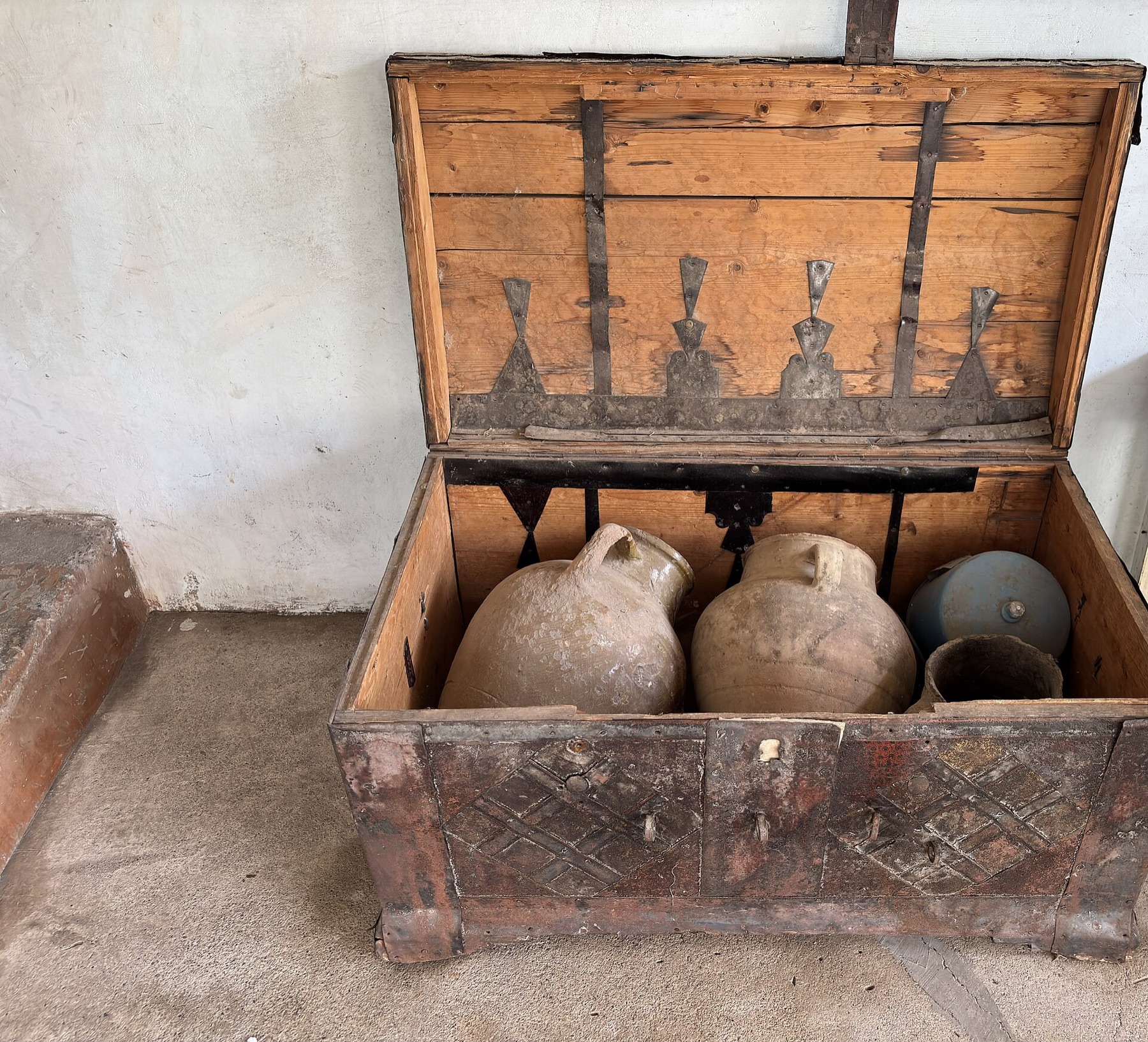 Armenian clay wine vessels stored inside an old wooden chest